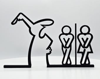 May include: Black and white silhouette wall decor featuring a person with a raised arm pointing to two stick figures in a bathroom stall. The stick figures are facing each other and have their hands on their hips.
