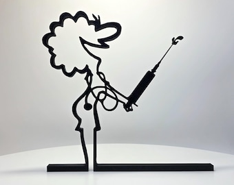 May include: A black, flat, linear sculpture depicting a stylized figure with curly hair, wearing a stethoscope around the neck and holding a syringe. The figure is constructed from a continuous black outline and stands on a flat base.