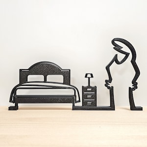 Peut inclure: Silhouette noire d'un lit, d'une table de chevet et d'une personne debout à côté du lit. Le lit a une tête de lit et un pied de lit. La table de chevet a un tiroir et une lampe. La personne est debout, les bras le long du corps.