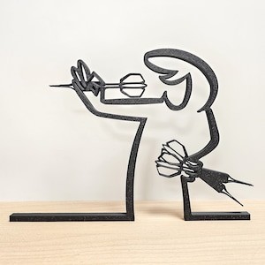 May include: Black metal sculpture of a person throwing a dart. The sculpture is on a black base.