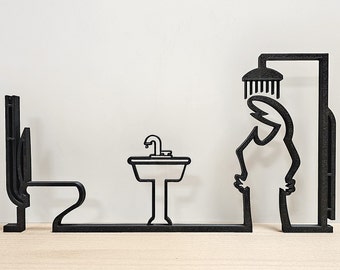 May include: Black metal bathroom art piece depicting a toilet, sink, and a person under a shower head. The minimalist design features a continuous line connecting the elements, creating a unique and modern aesthetic. The artwork is set against a neutral background.