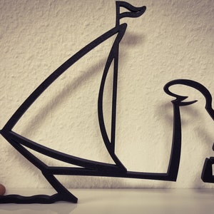 Può includere: Silhouette nera di una persona che tiene una barca a vela, la persona è inginocchiata e la barca a vela è sollevata sopra la sua testa.