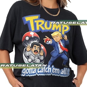 Può includere: T-shirt nera con una grafica a cartoni animati con la parola "TRUMP" in giallo e blu e due personaggi in un design a tema Pokémon. È presente anche il testo "gonna catch 'em all!".