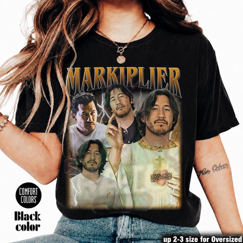 May include: Black t-shirt featuring a graphic of Markiplier in various poses with the word "MARKIPLIER" in gold lettering. The shirt has a vintage look, with the words "COMFORT COLORS" and "Black color" printed on the lower left.