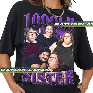 Może przedstawiać: Czarny T-shirt z fioletowym nadrukiem przedstawiającym pięć kobiet i tekst "1000 Sister".