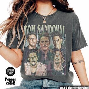 Könnte beinhalten: Dunkelgraues Comfort Colors T-Shirt mit einer Grafik von Tom Sandoval und dem Text "TOM SANDOVAL". Das Shirt hat einen Vintage-Look. Die Worte "Pepper color" sind auf dem Shirt aufgedruckt.