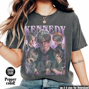 Peut inclure: Un t-shirt gris foncé Comfort Colors avec un graphisme d'un homme et le texte "KENNEDY Leon". Le design comprend plusieurs images du même homme avec des éclairs violets. Le t-shirt porte également le texte "Pepper color" et "up 2-3 size for Oversized".