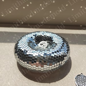 May include: A silver mirrored mosaic bowl with a tree of life pendant inside. The bowl is round and has a deep center.
