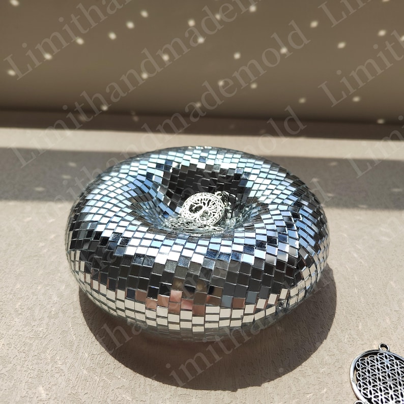 May include: A silver mirrored mosaic bowl with a tree of life pendant inside. The bowl is round and has a deep center.