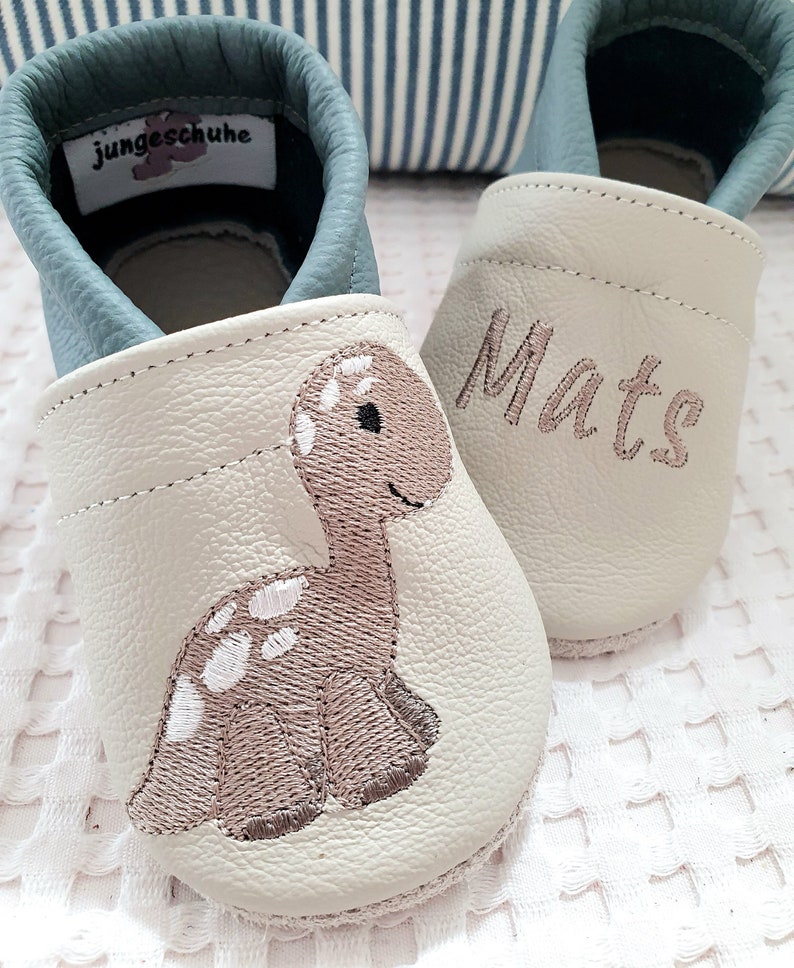 Handgefertigte Lederkrabbelschuhe in Dunkelblau und Mint mit süßem gesticktem Dino, weiche rutschhemmende Babyschuhe aus 100 Prozent Rindnappaleder – personalisierbar mit Namen, ideales Geschenk zur Geburt, Taufe oder für die Kita.