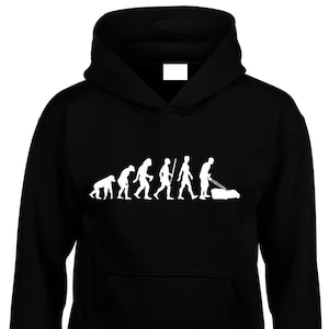 以下が含まれることがあります： 芝刈り機で芝生を刈っている男性で終わる、人間の進化の白いグラフィックが描かれた黒いフード付きスウェットシャツ。