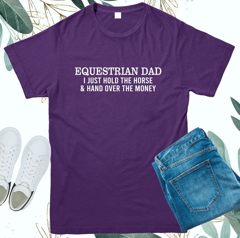 May include: Purple t-shirt with white text that reads "Equestrian Dad I just hold the horse & hand over the money".