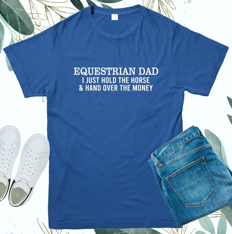 May include: A royal blue t-shirt with white text that reads "Equestrian Dad I just hold the horse & hand over the money".