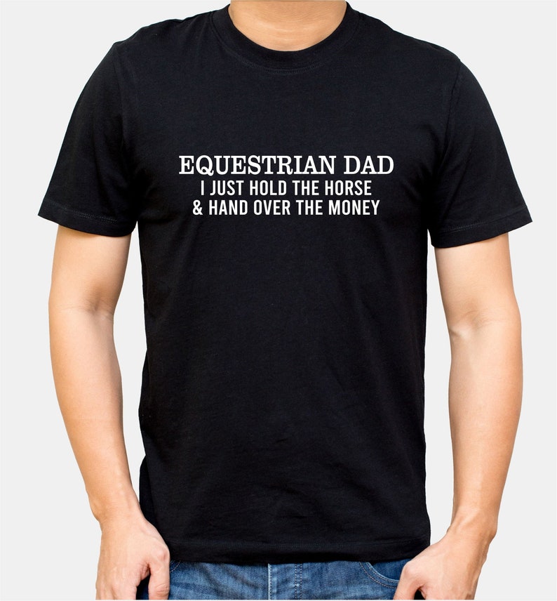 May include: Black t-shirt with white text that reads "Equestrian Dad I just hold the horse & hand over the money"