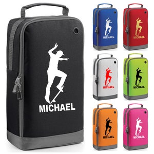 Könnte beinhalten: Eine rechteckige Schuh-Tasche mit Reißverschluss, Tragegriff und Belüftungsöse. Die Tasche zeigt eine Grafik einer Person auf einem Skateboard und den Namen MICHAEL in weißem Druck. Erhältlich in Schwarz, Blau, Rot, Weiß, Limettengrün, Orange und Pink.
