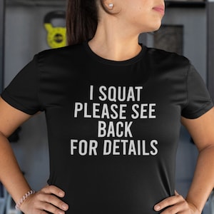 Può includere: Maglietta nera con testo bianco che dice "I SQUAT PLEASE SEE BACK FOR DETAILS".