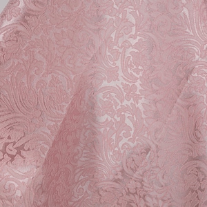 May include: A close-up of a pink fabric with a detailed floral pattern. The fabric has a textured surface and a slight sheen, with the design appearing in a lighter shade of pink. The overall effect is elegant and decorative.