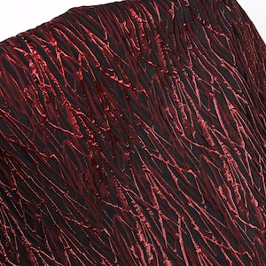 May include: Close-up of a textured fabric with a black base and a pattern of red, vein-like lines. The fabric has a crinkled appearance, creating depth and visual interest. The color palette is a combination of deep red and black.