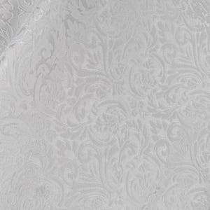 May include: White fabric with a detailed, embossed floral pattern. The design features swirling leaves and stems, creating a textured, elegant appearance. The fabric is folded, showing the pattern's repeating nature.