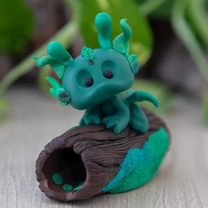Mythael - polymer clay dragon figurine on a tree log