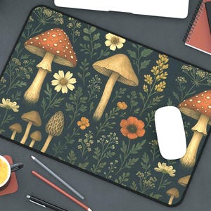 May include: A dark blue mousepad with a repeating pattern of red and white mushrooms, green leaves, and yellow flowers.