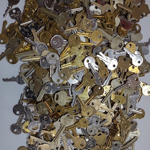 May include: A large pile of assorted keys, mostly brass and silver in color. Some keys have markings like "USA" and "6.S.27".