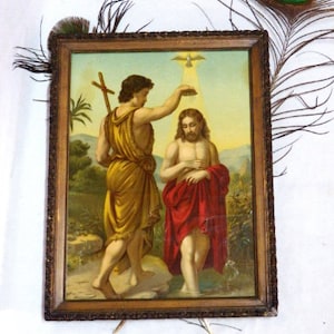 May include: A framed painting depicting a religious scene of the baptism of Jesus. The painting shows John the Baptist pouring water over Jesus' head, with a dove descending from the sky above. The painting is set in a landscape with trees and water.