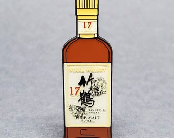 Könnte beinhalten: Eine Schwarzweißillustration einer Flasche Taketsuru 17 Jahre alter reiner Malt Whisky. Die Flasche ist braun mit einem goldenen Verschluss und Etikett. Das Etikett trägt den Text "Taketsuru Whisky" und "Pure Malt" in Japanisch und Englisch.