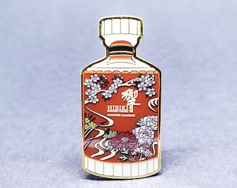 May include: Gold-colored enamel pin shaped like a bottle of Hibiki Suntory Whisky. The bottle is decorated with a red and white floral design and the text "Hibiki Suntory Whisky Japanese Harmony".