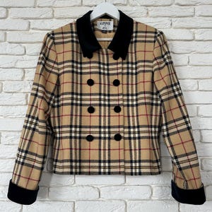 May include: A double-breasted jacket featuring a tan, black, and red plaid pattern. The garment has a black velvet collar and matching black velvet cuffs on the long sleeves. It includes six black buttons on the front and a Kasper ASL label.