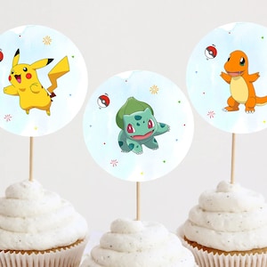 Puede incluir: Tres toppers redondos para cupcakes con personajes de Pokémon. Los toppers están impresos en papel blanco con un fondo azul acuarela. Los personajes son Pikachu, Bulbasaur y Charmander.