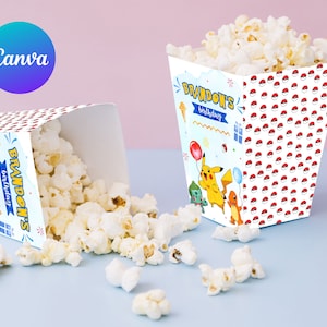 Puede incluir: Dos cajas de palomitas de maíz de cartón blanco con temática de Pokémon. Las cajas están decoradas con un patrón azul, amarillo y rojo. El texto en las cajas dice "Brandon's Birthday".