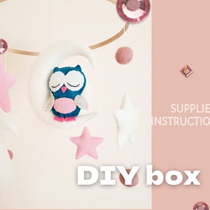 May include: DIY baby mobile kit with instructions. The mobile features a white felt crescent moon with a blue and pink owl, pink felt stars, and white felt stars.