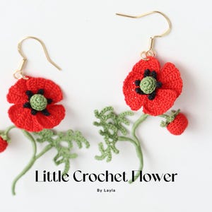 May include: A pair of crocheted poppy flower earrings with green leaves and stems. The earrings are red with black centers and green leaves. The text "Little Crochet Flower" and "By Layla" is below the earrings.