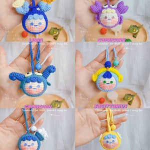 Puede incluir: Un conjunto de 12 amuletos de crochet con los signos del zod&iacute;aco, cada uno con un color y dise&ntilde;o diferente. Los amuletos est&aacute;n hechos de hilo y tienen un aspecto lindo y de dibujos animados. Los amuletos est&aacute;n unidos a una cuerda y tienen una peque&ntilde;a campana al final.