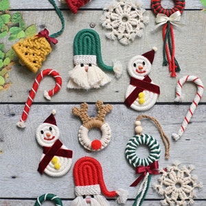 May include: A collection of handmade Christmas ornaments made from macrame. The ornaments include a snowman, Santa Claus, reindeer, candy cane, bell, and snowflake. The ornaments are all white, red, green, and brown.