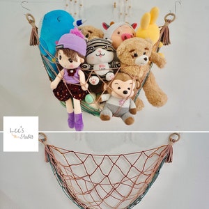 May include: A macramé hammock net filled with various plush toys, including a blue whale, a doll, a tiger, a bear, and a monkey. The net is suspended from the ceiling, showcasing a decorative storage solution for children's toys.