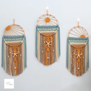 May include: Three macrame wall hangings featuring circular wooden frames with sunburst designs in mustard yellow, teal, and beige. Each piece incorporates intricate knotted patterns, hanging yarn fringe, and a central starfish accent with wooden beads.