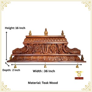 May include: A brown teak wood wall shelf featuring intricate carvings of peacocks, a wheel, and a central symbol. The shelf includes three small hanging brass bells. Dimensions are 40.64 cm in height, 91.44 cm in width, and 5.08 cm in depth.