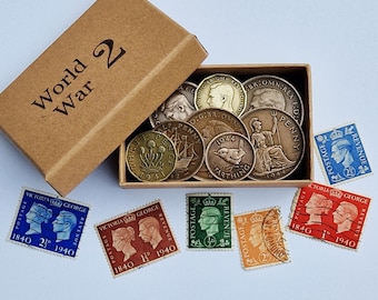 May include: A brown cardboard box labelled World War 2 containing various vintage British coins, including a 1941 three pence and a 1944 farthing. Several postage stamps from 1840 to 1940 featuring portraits of Victoria and George are arranged nearby.