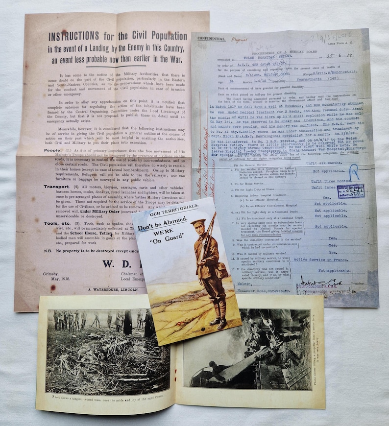 May include: A selection of historical documents, including instructions for the civil population, a medical report, and a propaganda card featuring a soldier. The items are displayed on a light surface, suggesting a glimpse into the past. Measurements are not applicable.