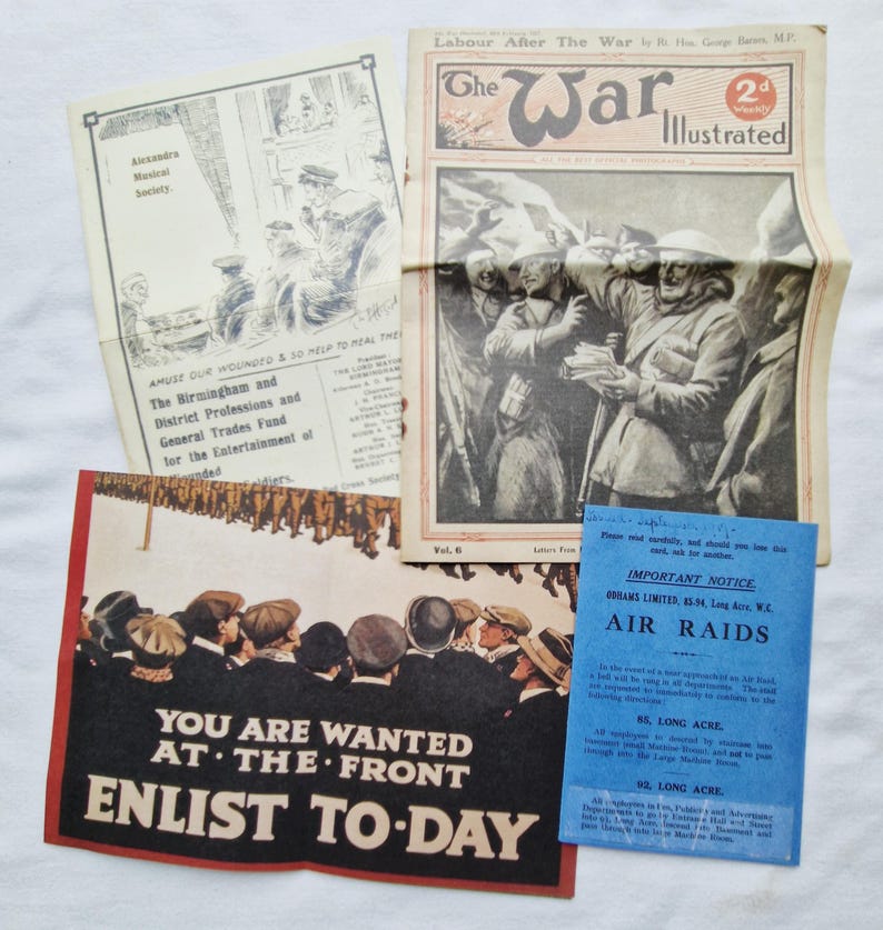 May include: A selection of historical printed materials, including a newspaper called "The War Illustrated," a recruitment poster with the text "You are wanted at the front, enlist today," and other documents. The items show signs of age.