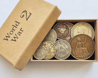 May include: A rectangular cardboard box labelled World War 2 containing a collection of vintage British coins. The coins include various denominations such as a 1939 farthing, a 1944 one penny, a 1939 one shilling, and a 1942 three pence piece.