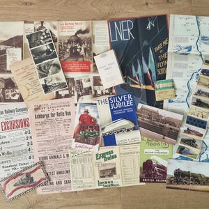 May include: A selection of vintage railway-themed ephemera, including brochures, maps, and tickets, arranged on a wooden surface. The items feature various colors and text, evoking a sense of nostalgia for train travel and the British railway system.