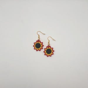 Red sunflower lace earrings crafted with vibrant embroidery thread to make a stunning addition to any outfit, adding a feminine and delicate touch. These earrings are super lightweight, unique, and make a wonderful gift for any occasion. The hypoallergenic French ear wire hooks and jump rings are made from stainless steel and include clear silicone earring backs. Measurements: Refer to Size / Select an option