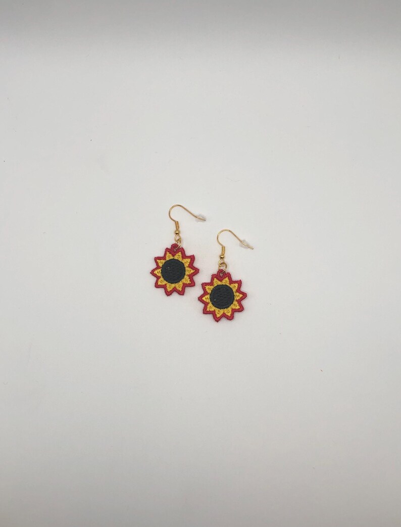 Red sunflower lace earrings crafted with vibrant embroidery thread to make a stunning addition to any outfit, adding a feminine and delicate touch. These earrings are super lightweight, unique, and make a wonderful gift for any occasion. The hypoallergenic French ear wire hooks and jump rings are made from stainless steel and include clear silicone earring backs. Measurements: Refer to Size / Select an option