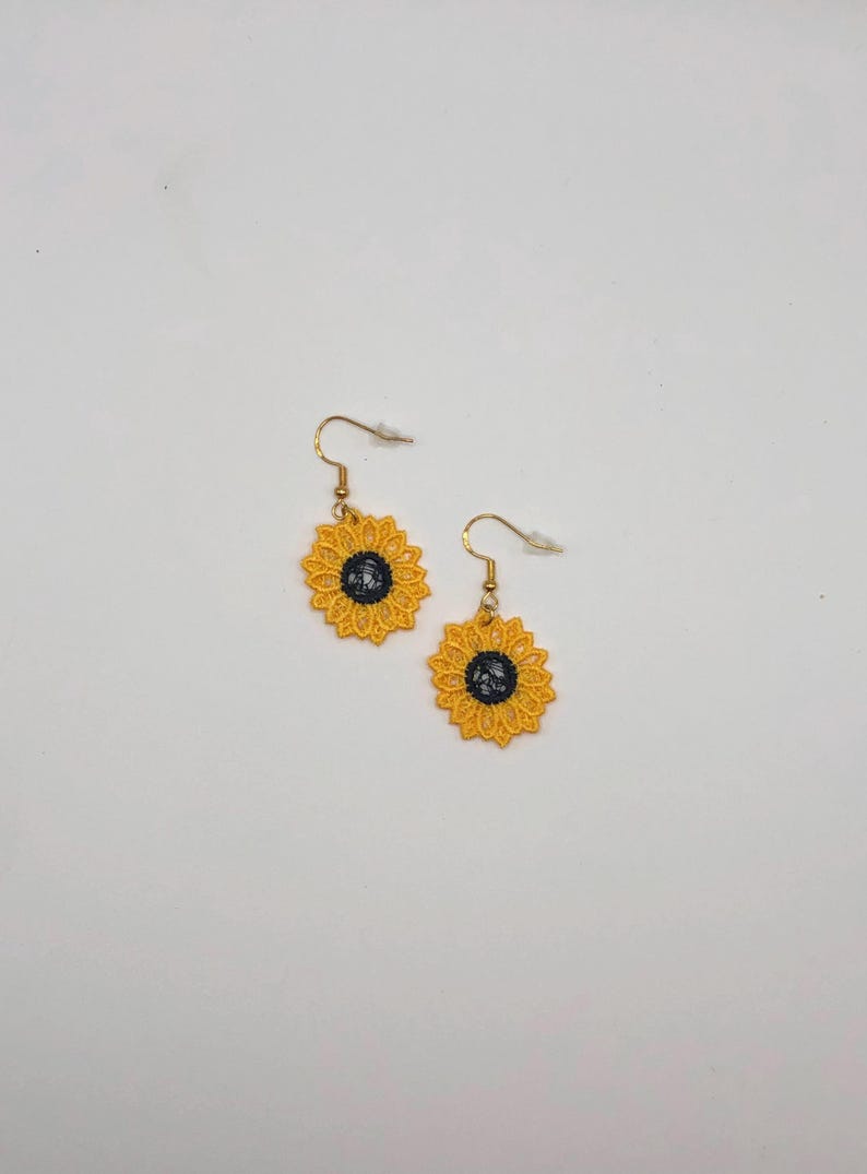 Yellow sunflower lace earrings crafted with vibrant embroidery thread to make a stunning addition to any outfit, adding a feminine and delicate touch. These earrings are super lightweight, unique, and make a wonderful gift for any occasion. The hypoallergenic French ear wire hooks and jump rings are made from stainless steel and include clear silicone earring backs. Measurements: Refer to Size / Select an option