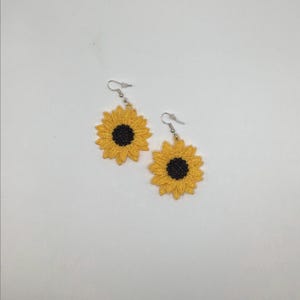 Yellow sunflower lace earrings crafted with vibrant embroidery thread to make a stunning addition to any outfit, adding a feminine and delicate touch. These earrings are super lightweight, unique, and make a wonderful gift for any occasion. The hypoallergenic French ear wire hooks and jump rings are made from stainless steel and include clear silicone earring backs. Measurements: Refer to Size / Select an option
