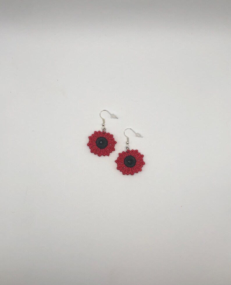 Red sunflower lace earrings crafted with vibrant embroidery thread to make a stunning addition to any outfit, adding a feminine and delicate touch. These earrings are super lightweight, unique, and make a wonderful gift for any occasion. The hypoallergenic French ear wire hooks and jump rings are made from stainless steel and include clear silicone earring backs. Measurements: Refer to Size / Select an option