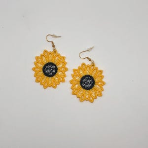 Yellow sunflower lace earrings crafted with vibrant embroidery thread to make a stunning addition to any outfit, adding a feminine and delicate touch. These earrings are super lightweight, unique, and make a wonderful gift for any occasion. The hypoallergenic French ear wire hooks and jump rings are made from stainless steel and include clear silicone earring backs. Measurements: Refer to Size / Select an option